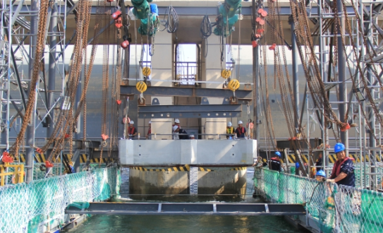 鋼絲繩電動葫蘆吊裝，倒鏈微調，確保導流墩預制塊精準安裝